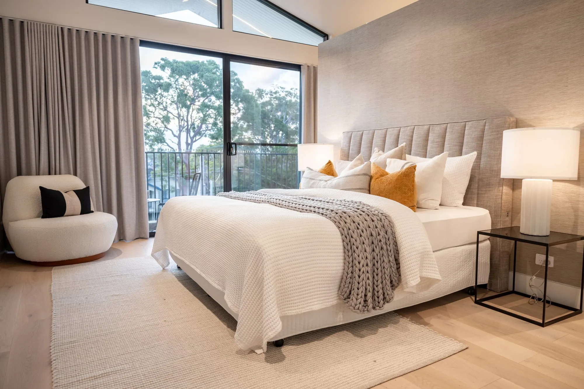 Main bedroom with a vaulted ceiling and treetop view