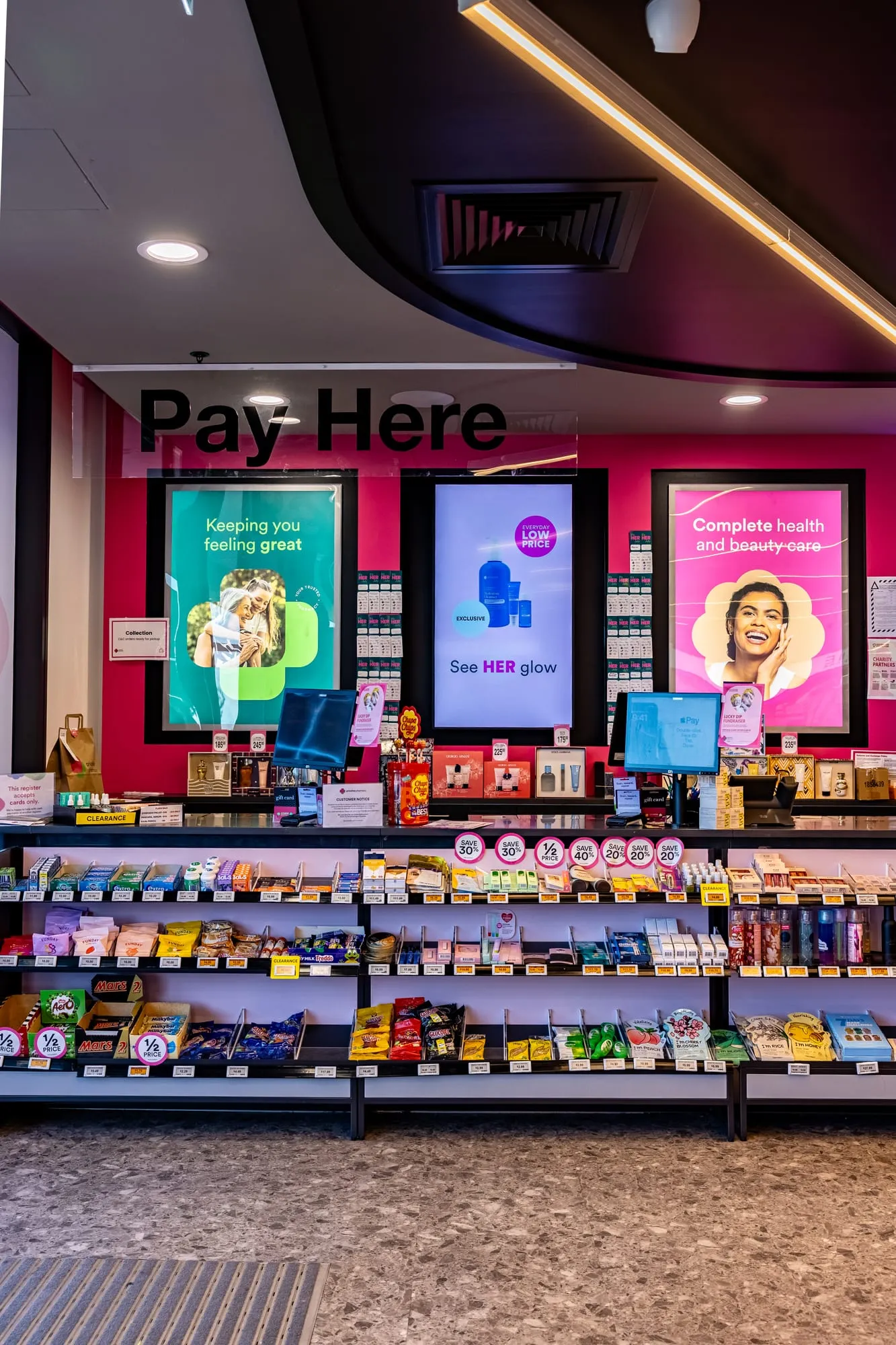 Pay Here service counter with backlit branding and digital screens