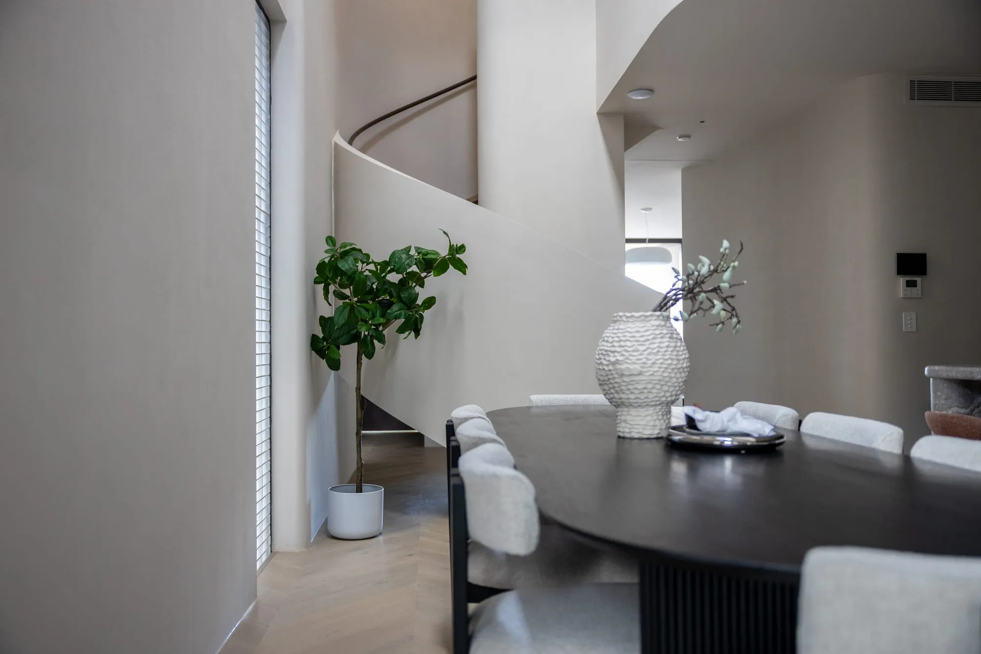 Dining setting beside the curved staircase