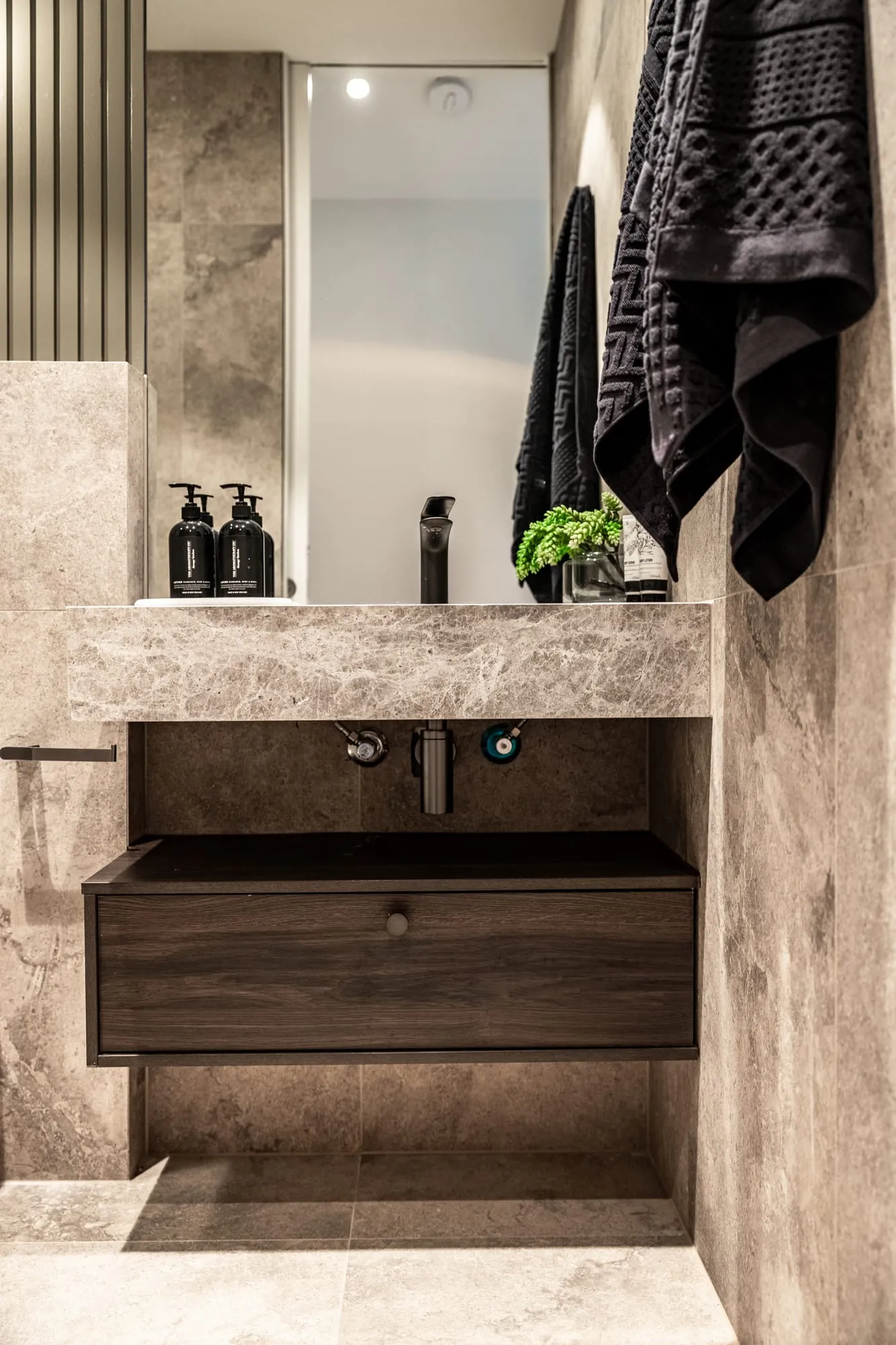 Stone-lined ensuite with a timber vanity