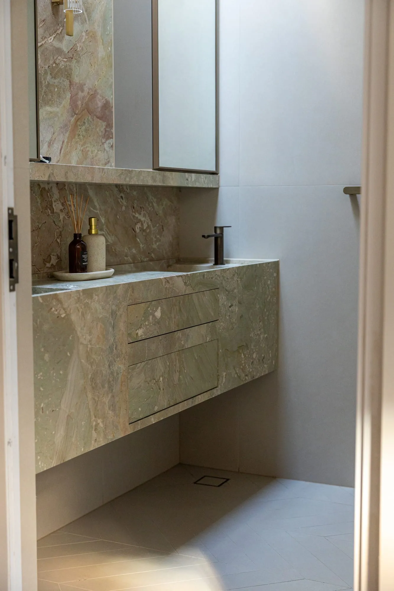 Ensuite with a full-height natural stone vanity