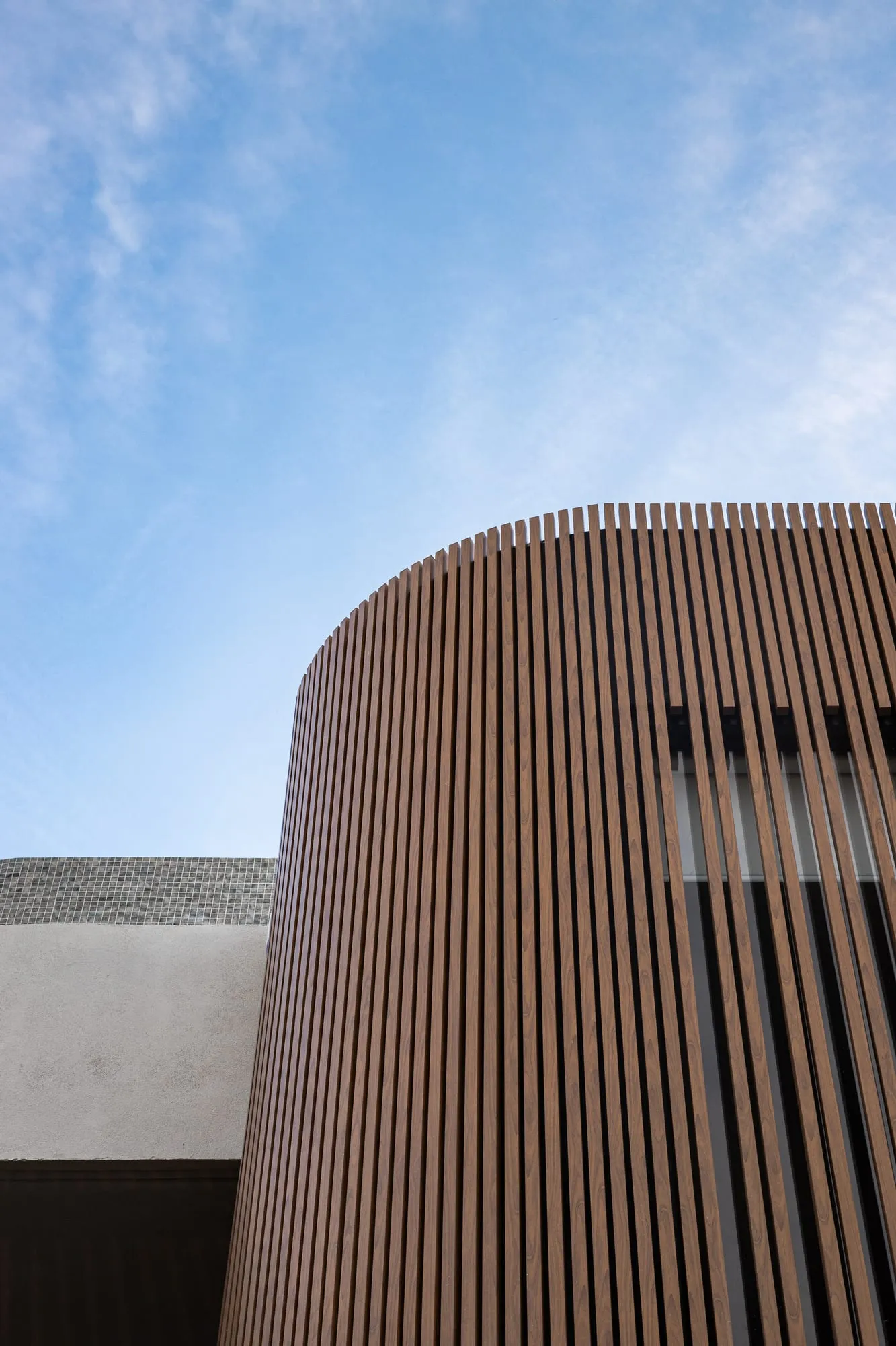 Vertical timber battens curving across the home's facade