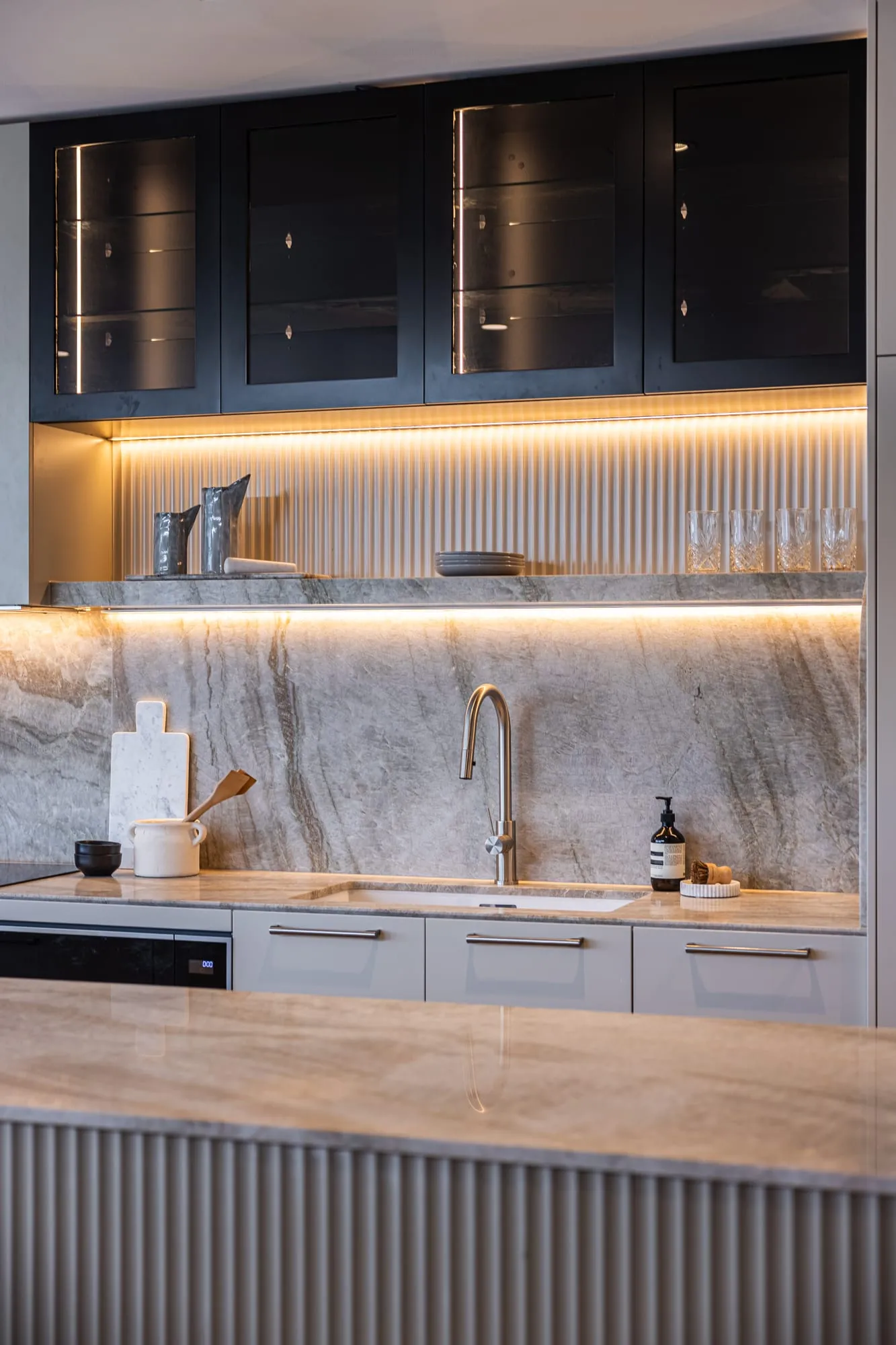 Natural stone splashback and brass tapware in the kitchen