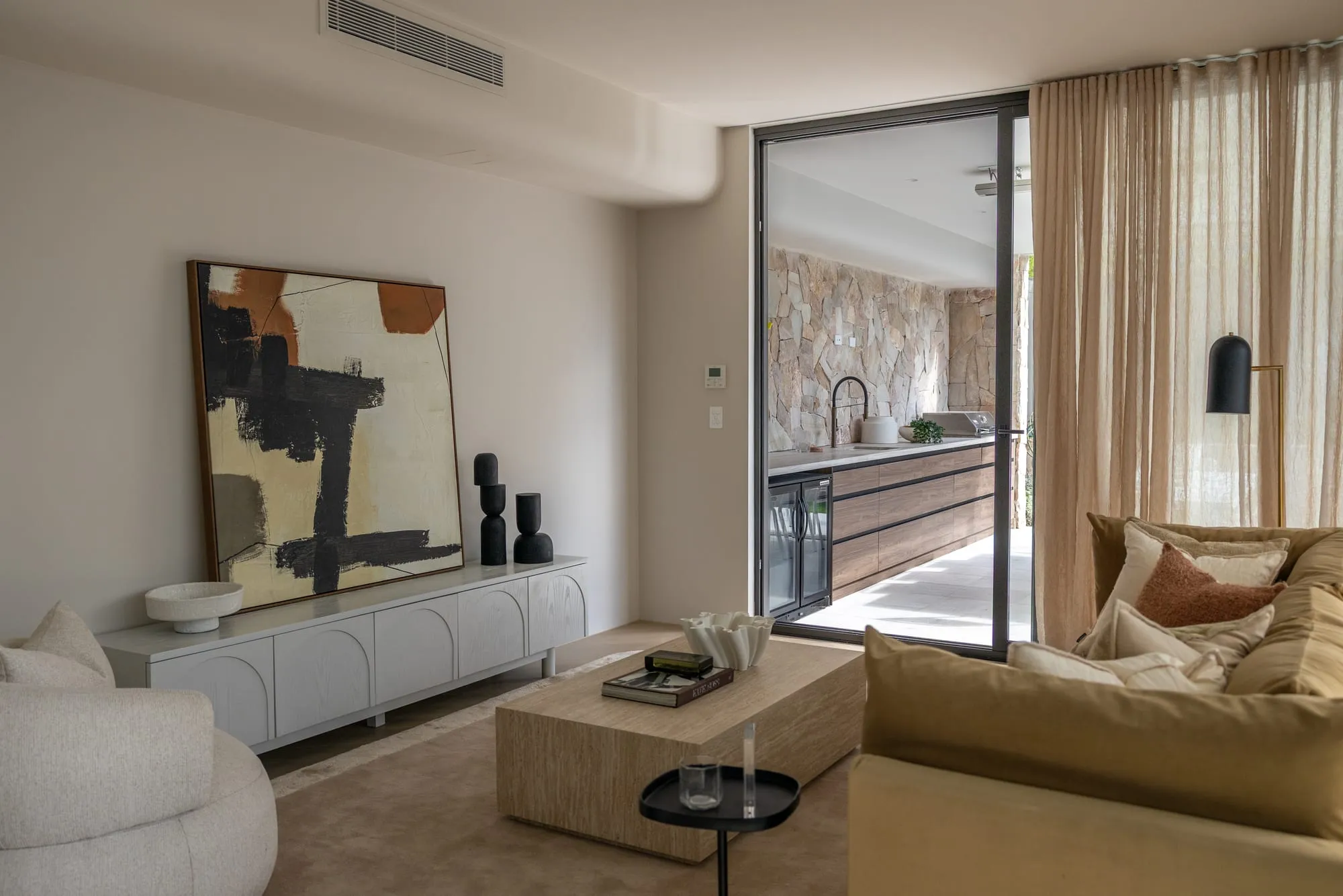 Formal living area with soft neutral furnishings and artwork