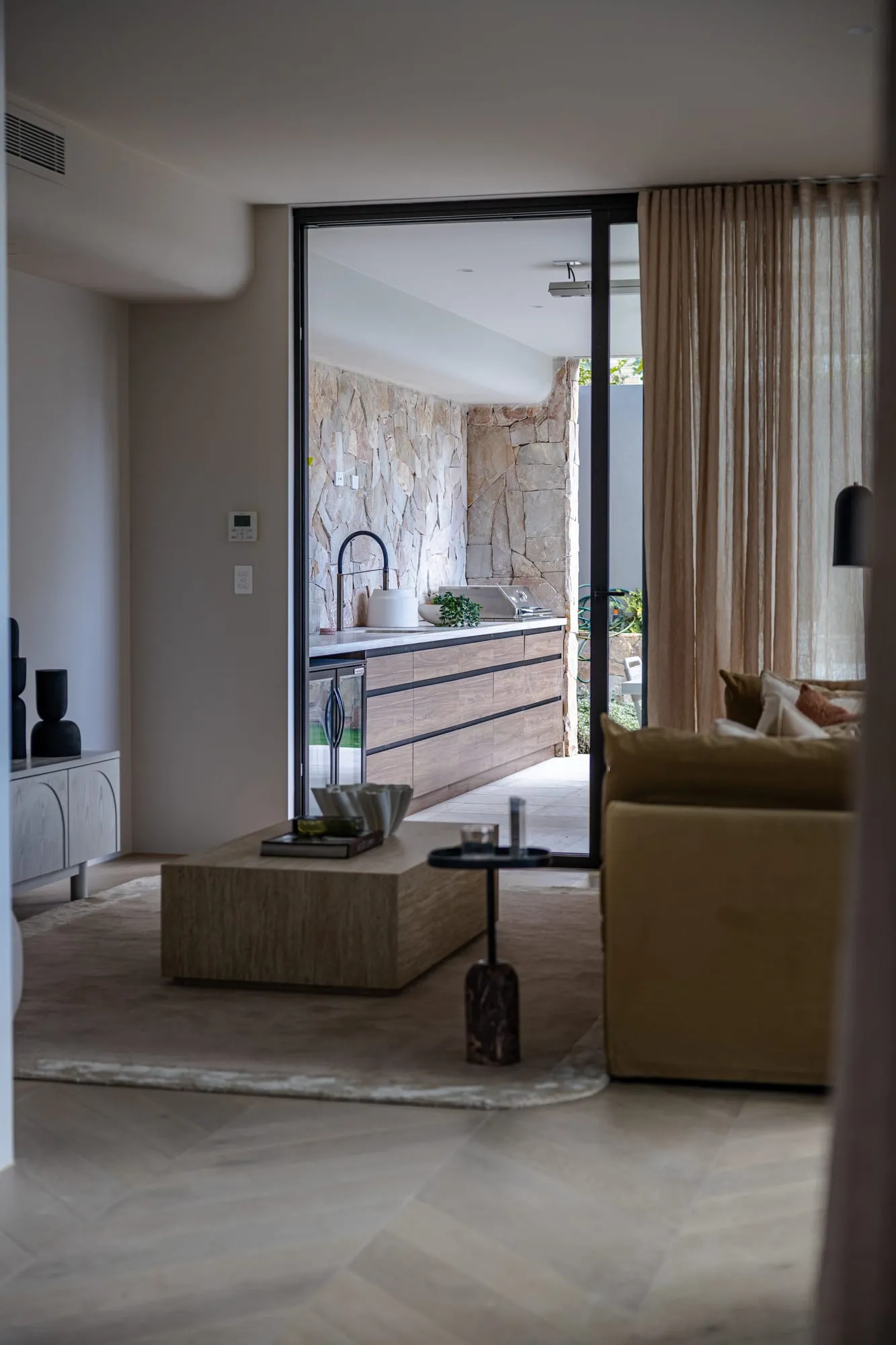 Living room opening to the garden through full-height glazing