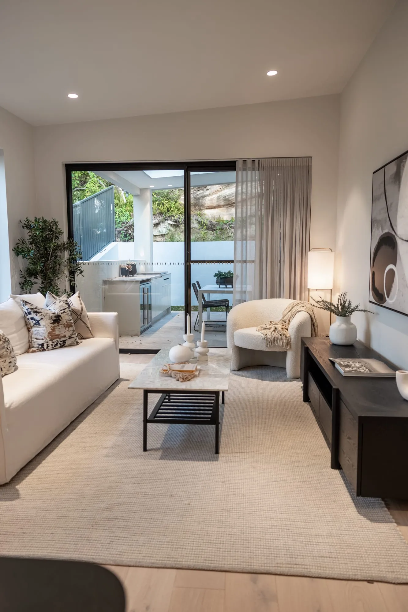 Living room opening to the garden through full-height sliders