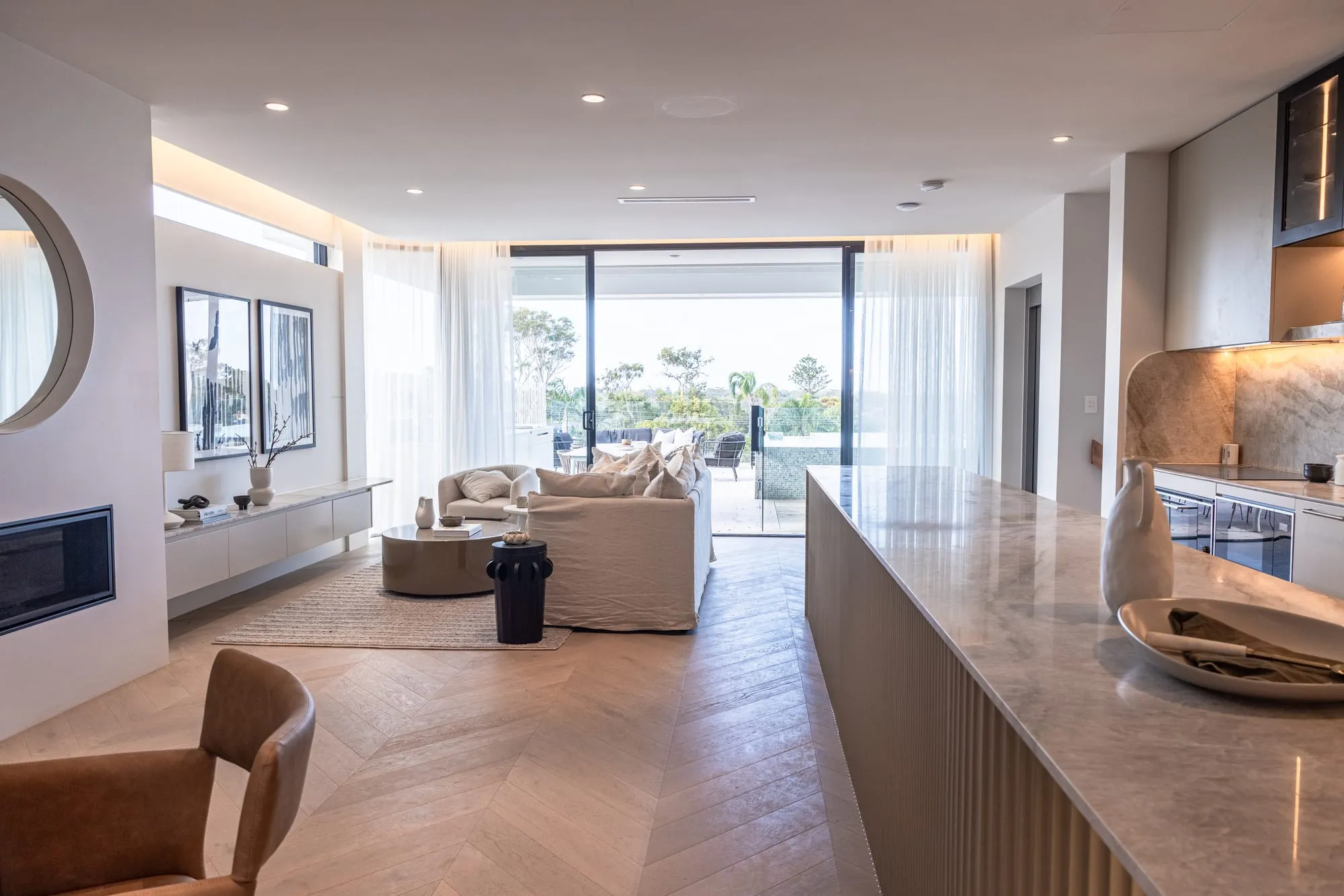 Living room opening through sheer curtains to the view