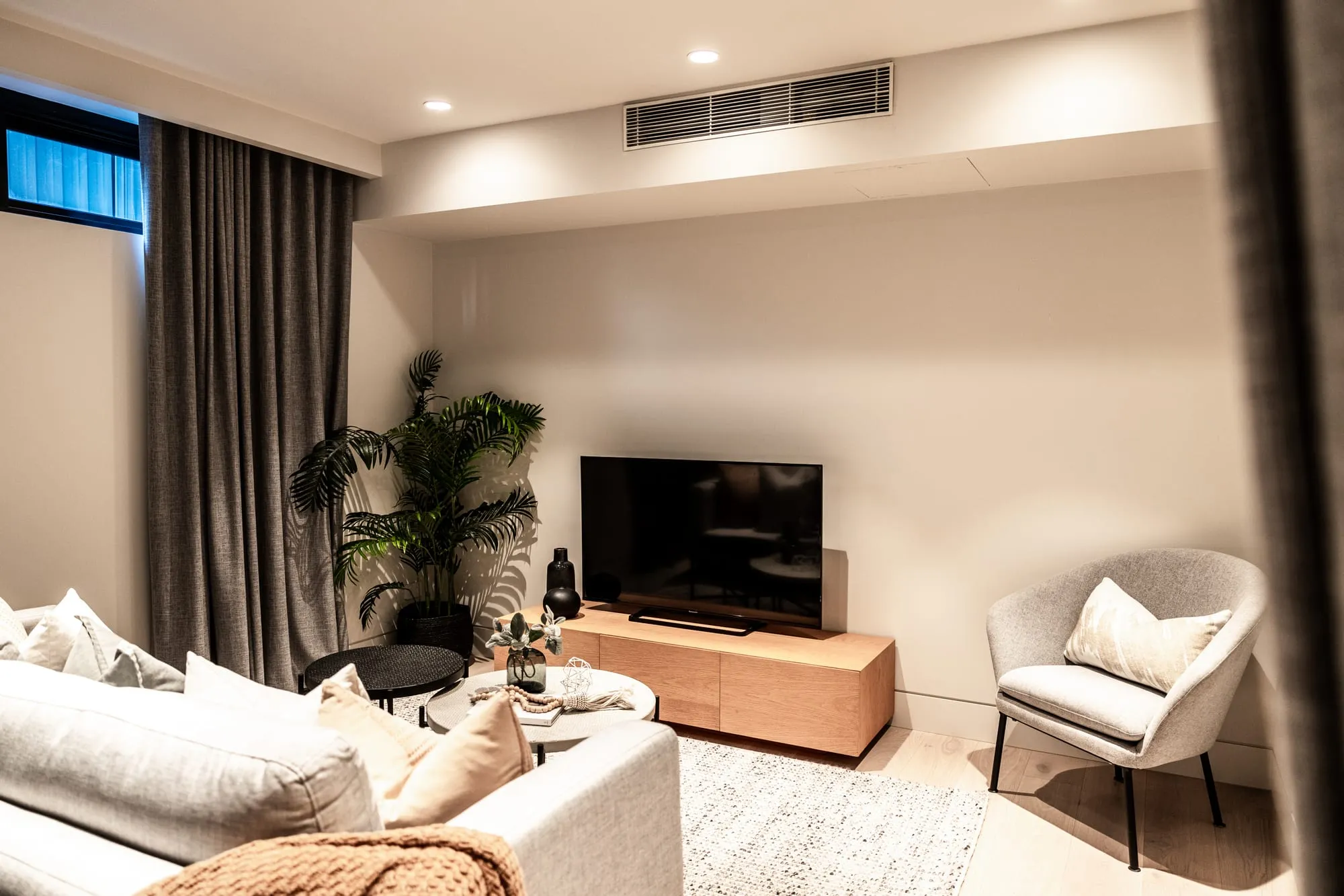 Warm living area with timber cabinetry and soft seating