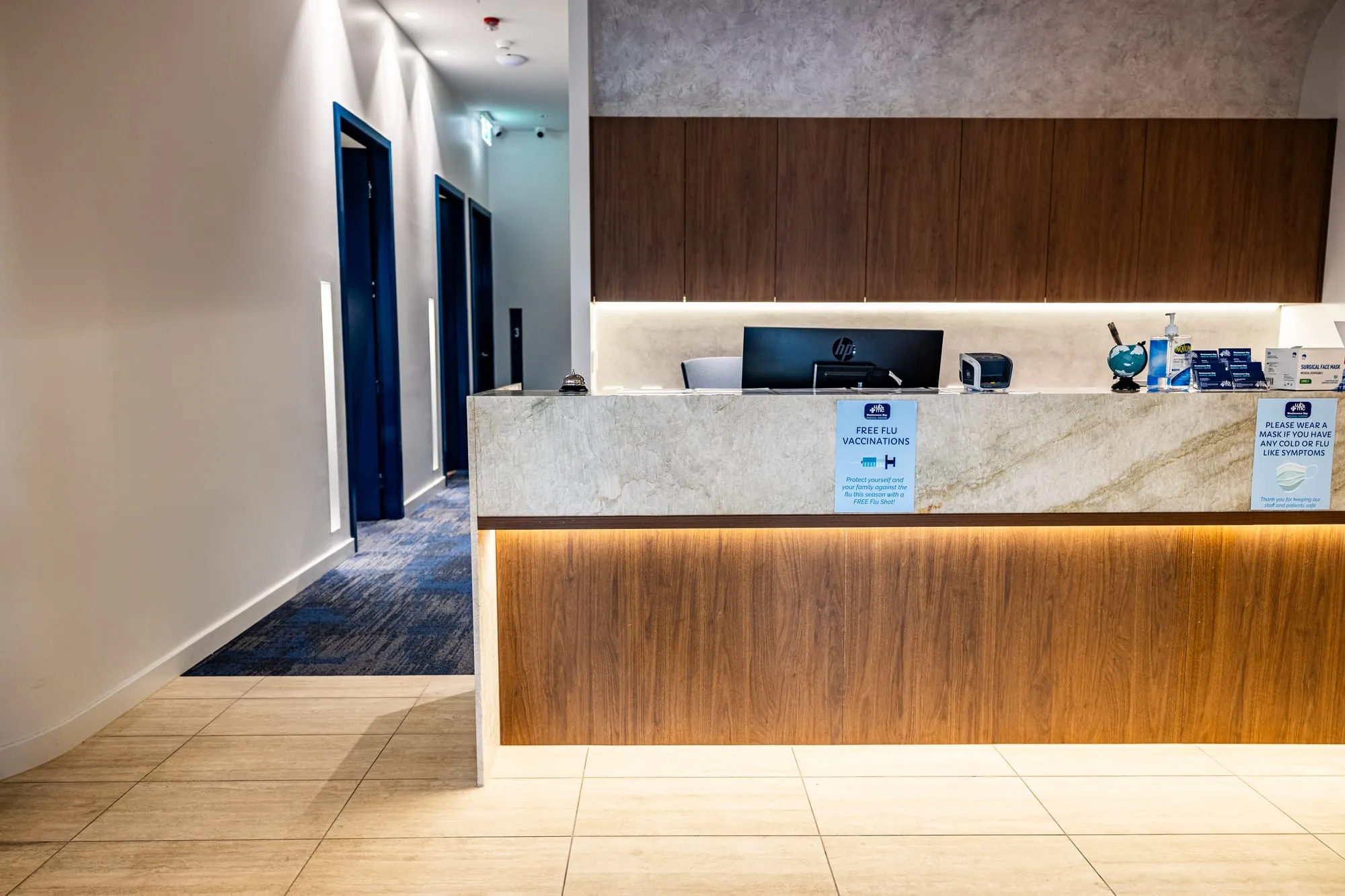 Reception desk with timber joinery and a natural stone benchtop