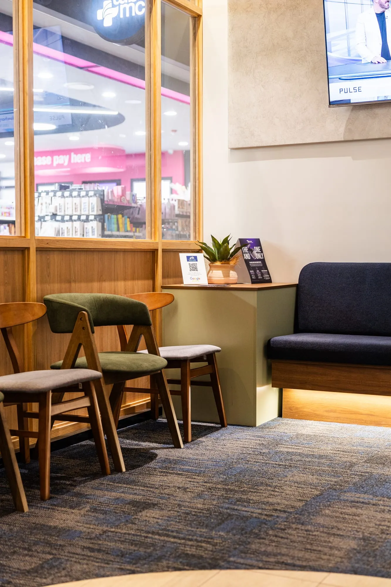 Seating area with green chairs beside the pharmacy