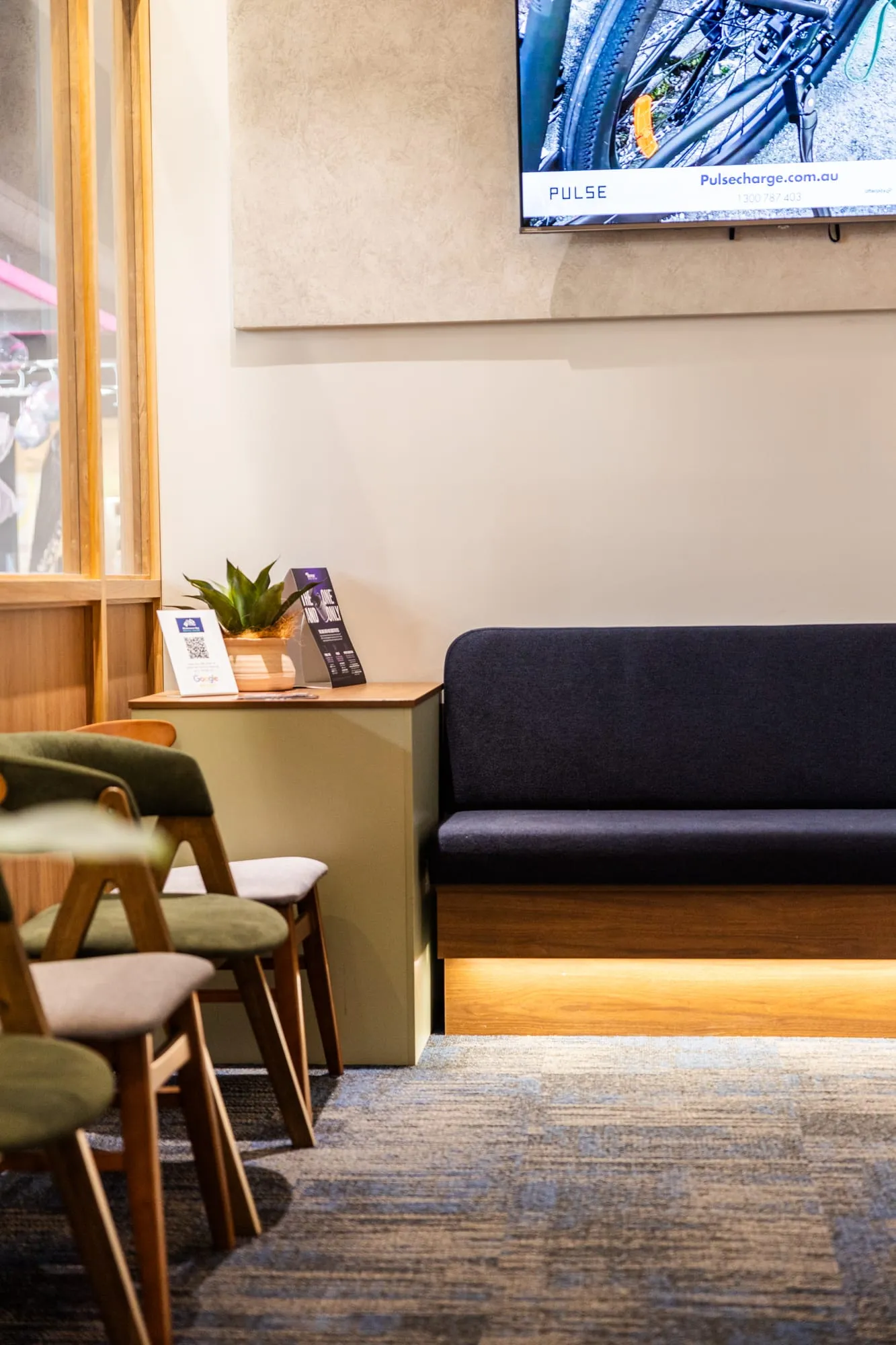 Waiting area with timber chairs and a cushioned bench