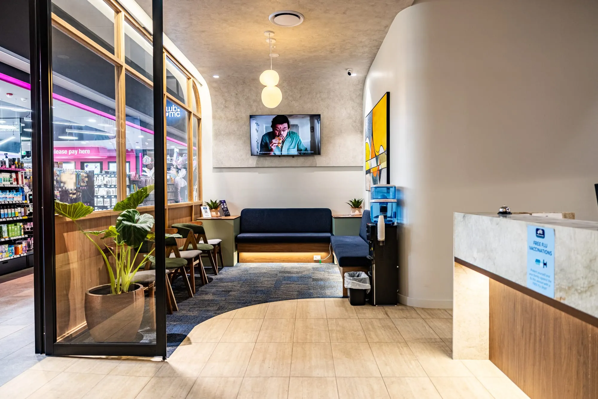 Waiting area with navy bench seating beside the pharmacy
