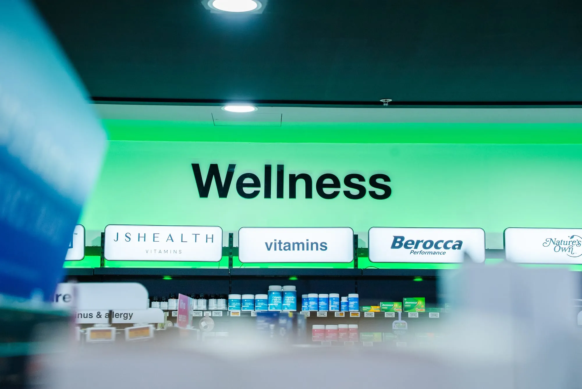 Backlit wellness signage over fitted shelving
